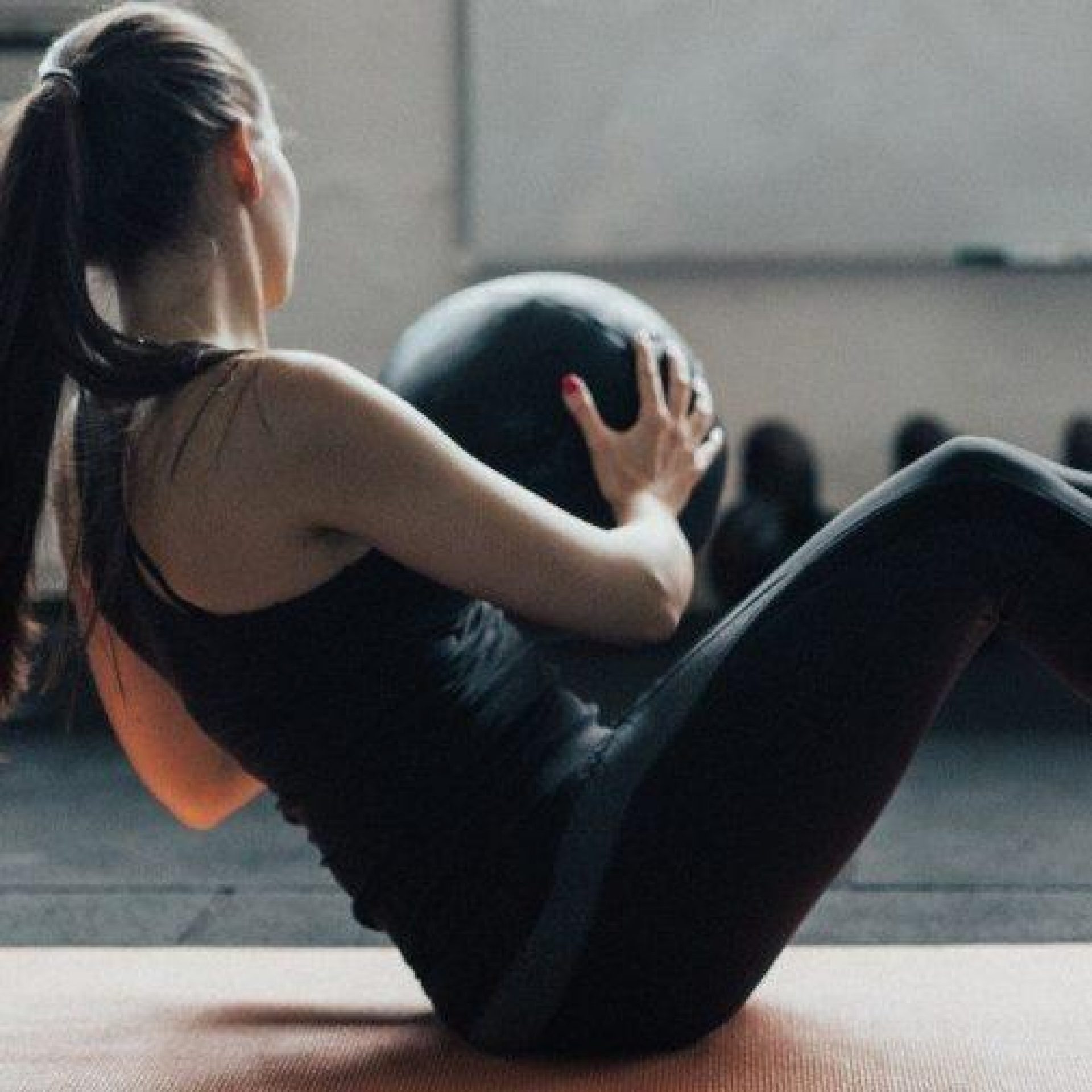 Fit Young Woman With Ponytail Uses Medicine Ball To Train Her Picture Id692888422