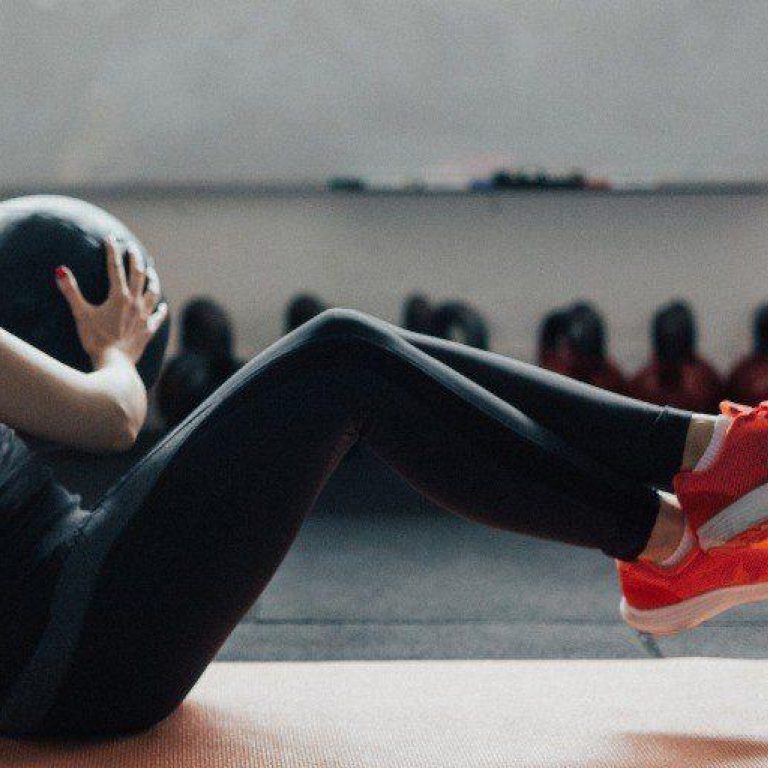 Fit Young Woman With Ponytail Uses Medicine Ball To Train Her Picture Id692888422